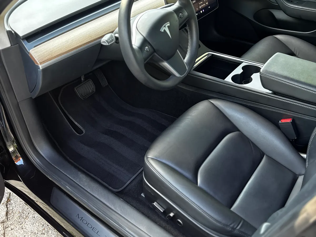 The same Tesla Model 3 after a Signature interior detail, carpet and floor mat clean