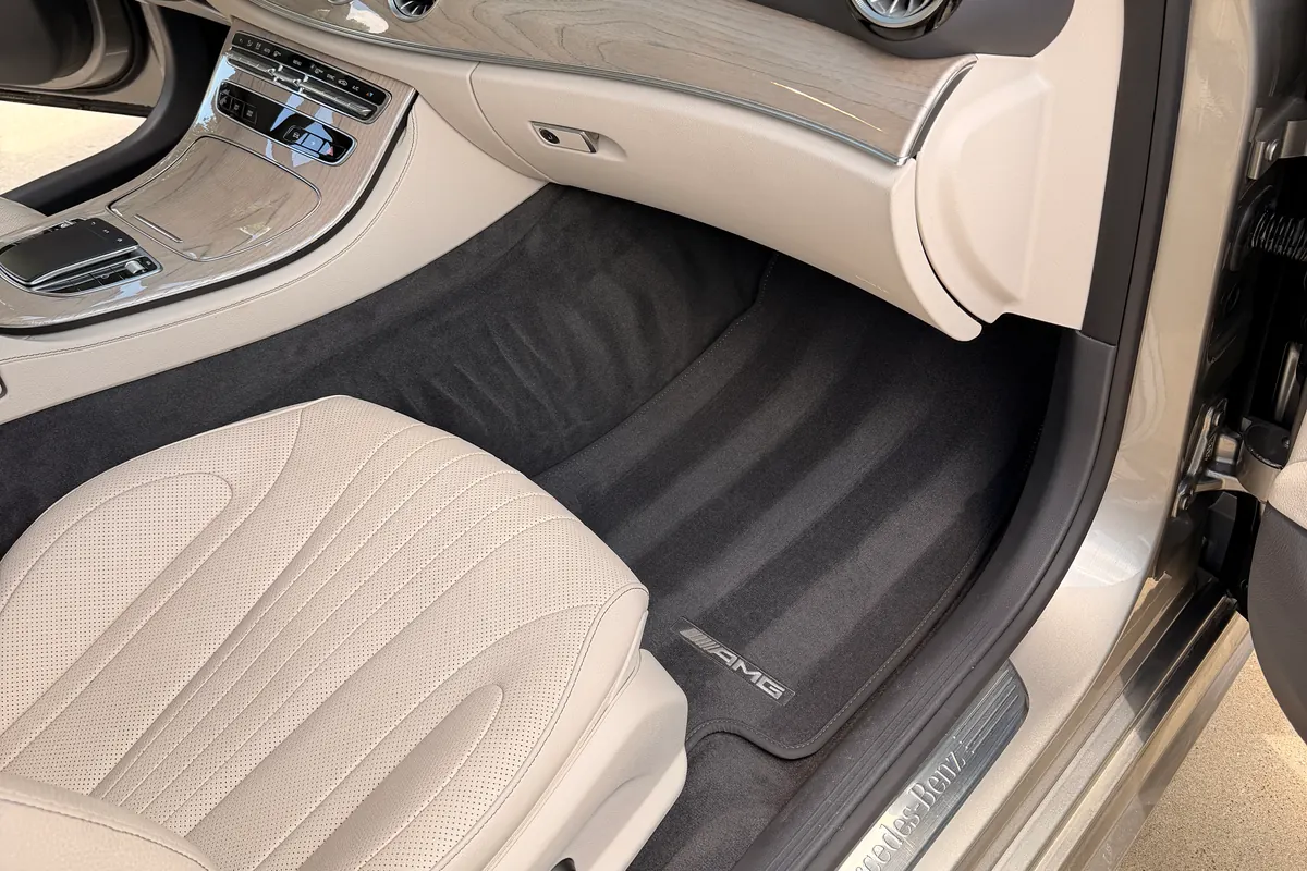 Detailed Mercedes-Benz interior with clean cream leather, dashboard, and carpet